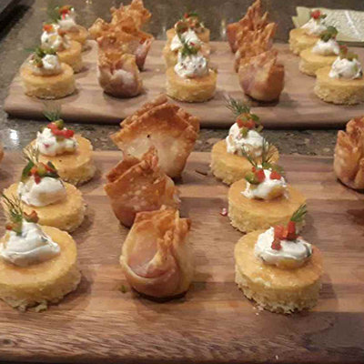 a variety of bite-sized hors d'oeuvres on a wooden platter